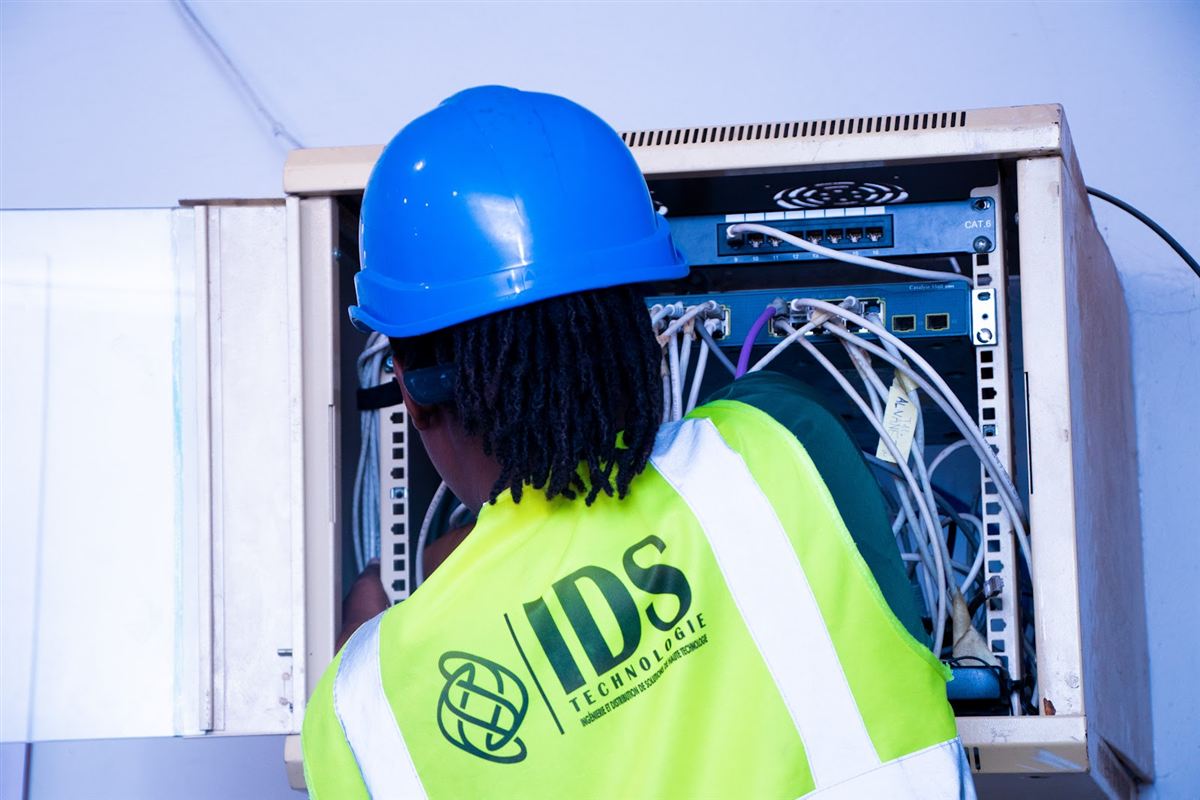 Ingénieure IDS intervenant sur un coffret de brassage réseau